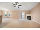 Inviting living room features a fireplace, neutral carpet, ceiling fan, and sliding glass door to a balcony at 11640 W 62Nd Pl # 203, Arvada, CO 80004