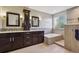 Modern bathroom with a double sink vanity, large soaking tub, tiled shower, and neutral color palette at 1300 W 13Th Ave, Broomfield, CO 80020