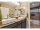 Well-lit bathroom with a double sink vanity, granite countertops, and a tiled shower at 1300 W 13Th Ave, Broomfield, CO 80020