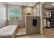 Elegant bathroom featuring a soaking tub, walk-in shower with stone accents, and a walk-in closet at 1300 W 13Th Ave, Broomfield, CO 80020