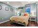 Cozy bedroom boasts a bright window, wooden floors, a queen bed, and calming light blue walls at 1300 W 13Th Ave, Broomfield, CO 80020