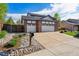 Wide driveway leading to a three-car garage, complemented by attractive landscaping and a mailbox at 1300 W 13Th Ave, Broomfield, CO 80020