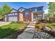 Charming two-story home with a well-manicured lawn, brick facade, and inviting entryway with beautiful landscaping at 1300 W 13Th Ave, Broomfield, CO 80020