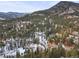 Aerial view of home and surrounding area in snowy mountains at 65 Cottonwood Dr, Evergreen, CO 80439