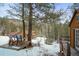 Small deck with chairs, snowy view, wooded area at 65 Cottonwood Dr, Evergreen, CO 80439