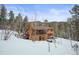 Two-story home exterior, wood siding, hot tub, snowy landscape at 65 Cottonwood Dr, Evergreen, CO 80439