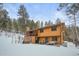 Two-story home exterior, wood siding, deck, snowy landscape at 65 Cottonwood Dr, Evergreen, CO 80439