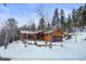 House exterior showcasing wood siding and snowy landscape at 65 Cottonwood Dr, Evergreen, CO 80439