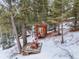 Small wooden studio with deck, snowy landscape at 65 Cottonwood Dr, Evergreen, CO 80439