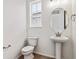 Clean powder room with pedestal sink and oval mirror at 674 Penn Rd, Elizabeth, CO 80107