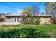 Large, grassy backyard with concrete patio, mature trees and partial fencing at 7065 Ingalls Ct, Arvada, CO 80003