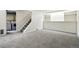 A large finished basement area with carpet, stairs to the first floor, and laundry area at 7065 Ingalls Ct, Arvada, CO 80003