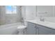 This bathroom offers a tub and shower combo with gray tile, plus a sink and vanity with a gray finish at 7065 Ingalls Ct, Arvada, CO 80003