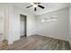 This bedroom features gray wood flooring, a window, a ceiling fan with light, and a closet at 7065 Ingalls Ct, Arvada, CO 80003