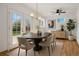 Elegant dining room with an oval table, stylish chairs, modern light fixture, and a view of the backyard at 7065 Ingalls Ct, Arvada, CO 80003