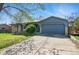 Charming single-story home featuring a blue exterior, arched doorway, and a two-car garage with a basketball hoop at 7065 Ingalls Ct, Arvada, CO 80003