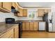 Well-lit kitchen with wooden cabinets, modern appliances, granite countertops and hardwood floors at 7065 Ingalls Ct, Arvada, CO 80003