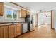 Well-lit kitchen with stainless steel appliances, wood cabinets, and hardwood floors at 7065 Ingalls Ct, Arvada, CO 80003