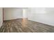 Bright living room featuring neutral walls and wood-look floors with a view into the hallway at 7065 Ingalls Ct, Arvada, CO 80003