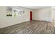 Bright living room featuring neutral walls, wood-look floors, and a red front door at 7065 Ingalls Ct, Arvada, CO 80003