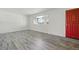 Bright living room featuring neutral walls, wood-look floors, and a red front door at 7065 Ingalls Ct, Arvada, CO 80003