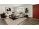 Bright living room with a cozy sectional sofa, modern artwork, and a dark wood coffee table on a light rug at 7065 Ingalls Ct, Arvada, CO 80003