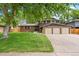 Charming two-story home with a well-manicured lawn and a three car garage at 9043 W Warren Dr, Lakewood, CO 80227