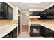 A galley kitchen featuring black cabinets with matching appliances at 9043 W Warren Dr, Lakewood, CO 80227