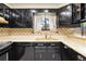 A galley style kitchen featuring shiny black cabinets and matching appliances at 9043 W Warren Dr, Lakewood, CO 80227
