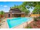 Backyard view of a large in-ground swimming pool surrounded by lush landscaping at 9043 W Warren Dr, Lakewood, CO 80227