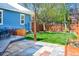 Inviting backyard with a stone patio, mature trees, and a grassy lawn at 3171 Fulton St, Denver, CO 80238