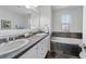 Bathroom featuring dual sinks, modern vanity, and soaking tub for relaxation at 3171 Fulton St, Denver, CO 80238