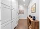 Hallway with ceramic tile flooring features storage cabinets and decorative table and art at 3171 Fulton St, Denver, CO 80238