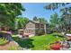 Landscaped backyard with patio, seating, and mature trees at 7264 Wembley Pl, Castle Pines, CO 80108