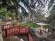 Beautiful backyard with a stone patio, fire pit, pergola, string lights, and lush landscaping creating an inviting outdoor oasis at 7264 Wembley Pl, Castle Pines, CO 80108