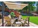 Cozy backyard with a fire pit under a pergola, perfect for outdoor entertaining and relaxation at 7264 Wembley Pl, Castle Pines, CO 80108