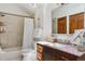 Well-lit bathroom featuring a shower-tub combo, vanity with storage, and updated fixtures at 7264 Wembley Pl, Castle Pines, CO 80108