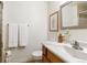 Clean bathroom with wood vanity, modern fixtures, and a decorative mirror at 7264 Wembley Pl, Castle Pines, CO 80108
