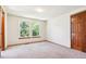 Spacious bedroom features large windows, neutral carpet, and a classic wood door at 7264 Wembley Pl, Castle Pines, CO 80108