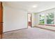 Bright bedroom with large windows, neutral carpet, and a glimpse into an attached bathroom at 7264 Wembley Pl, Castle Pines, CO 80108