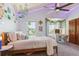Bright bedroom featuring a decorative ceiling fan and a well-lit vanity area at 7264 Wembley Pl, Castle Pines, CO 80108