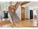 Staircase foyer with hardwood floors, wood trim, and a view to the second floor at 7264 Wembley Pl, Castle Pines, CO 80108