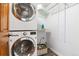 Efficient laundry room with stacked washer/dryer and shelving at 7264 Wembley Pl, Castle Pines, CO 80108