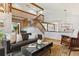 Open-concept living room with a wooden staircase, beamed ceiling, and hardwood flooring at 7264 Wembley Pl, Castle Pines, CO 80108