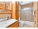 Bathroom featuring wood cabinets, a sink, a toilet, and a shower and tub combination behind a sliding glass door at 1759 Cedar St, Broomfield, CO 80020