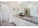 Bathroom featuring double sinks with granite countertops, a large mirror, and access to an enclosed shower at 2054 S Upham Way, Denver, CO 80227