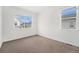 Vacant bedroom with plush carpeting, large window offering natural light, and neutral color palette at 2054 S Upham Way, Denver, CO 80227