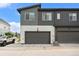 Modern two-story home featuring a two-car garage with gray door and nicely landscaped surroundings at 2054 S Upham Way, Denver, CO 80227