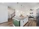 Spacious kitchen with island, granite countertops, a staircase, and sleek stainless steel appliances at 2054 S Upham Way, Denver, CO 80227