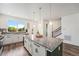 Bright kitchen featuring white cabinets, granite countertops, a large island, and modern pendant lighting at 2054 S Upham Way, Denver, CO 80227